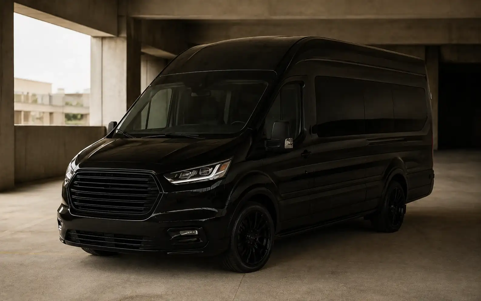 A black high-roof executive Sprinter van in a concrete parking structure.